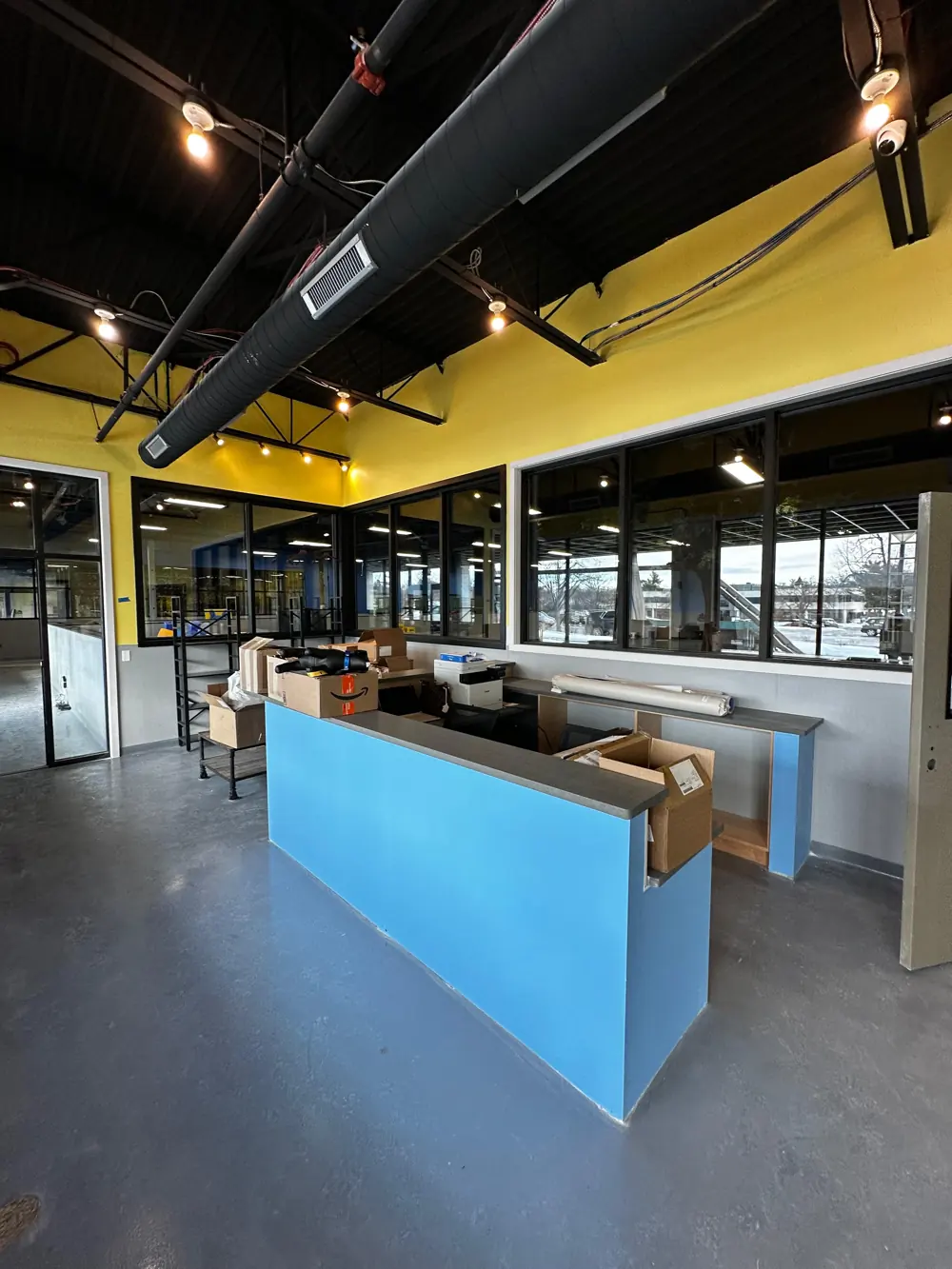 Reception counter in blue with yellow and grey walls