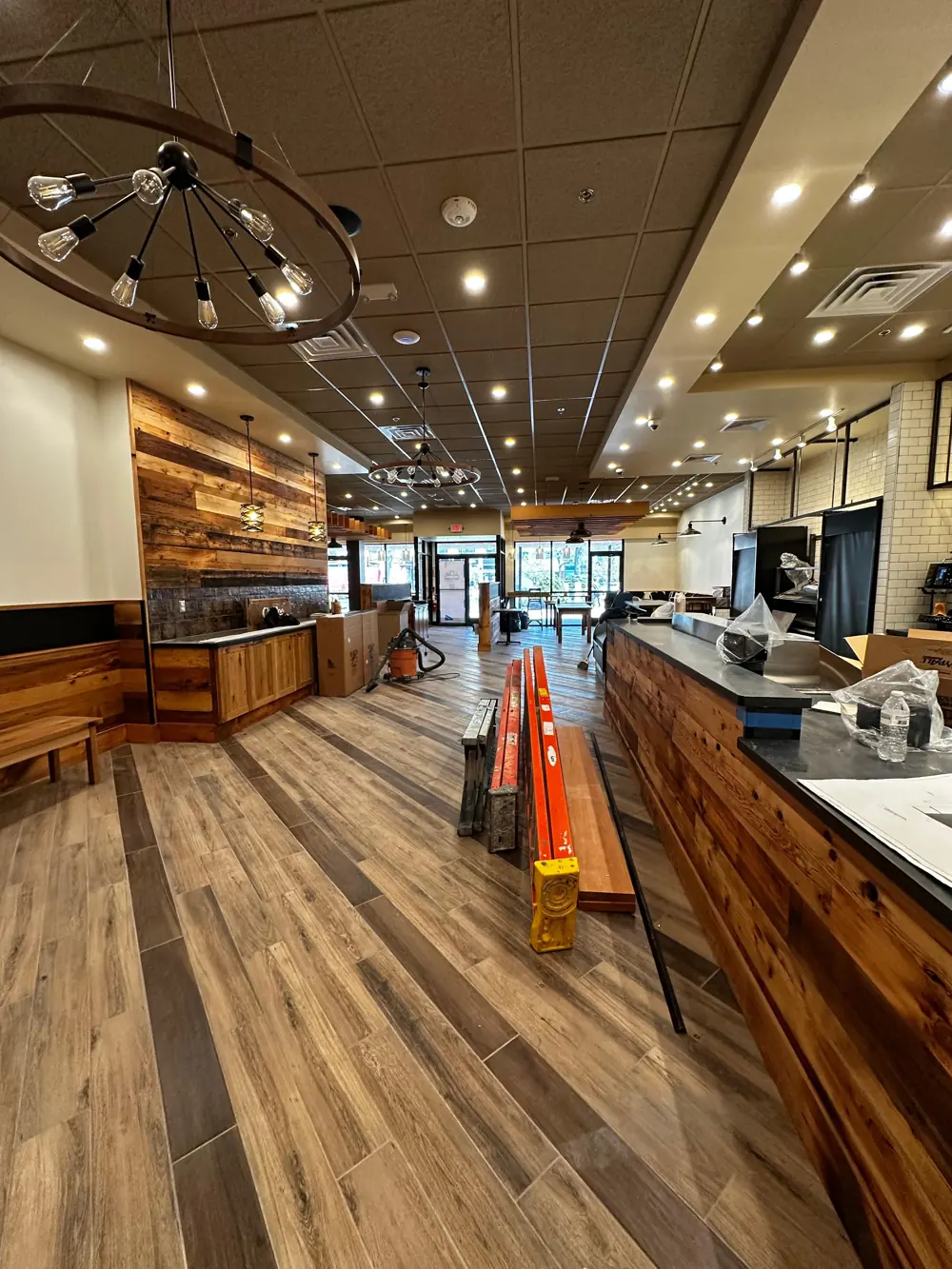 Restaurant interior with wood-paneled walls during finishing work